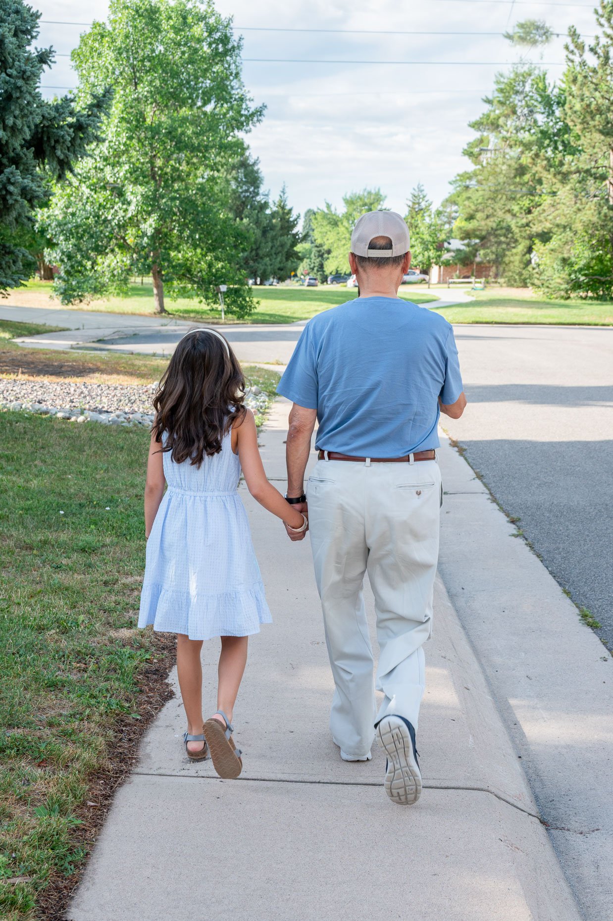 Grandfather and granddaughter walking down street
