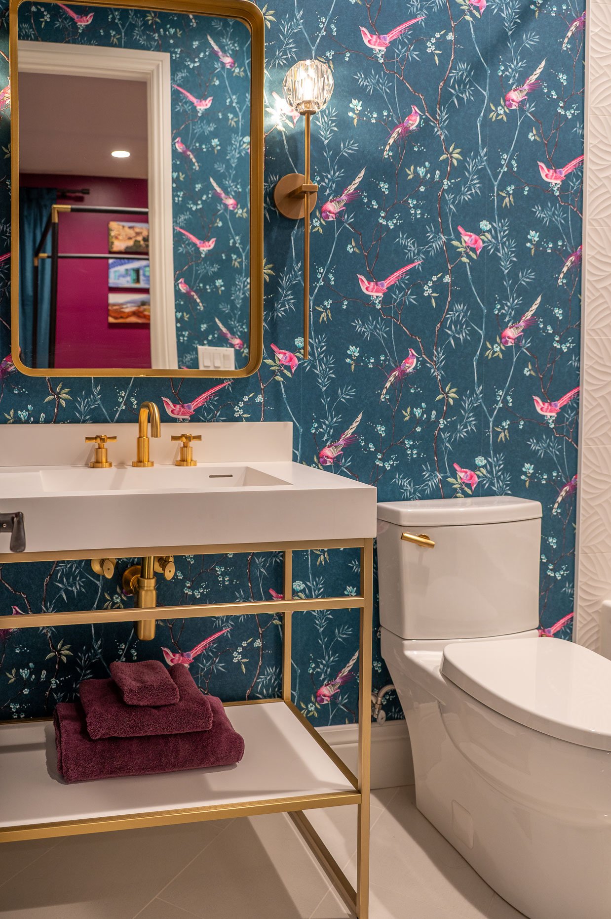 Gorgeous blue and pink wallpaper, white sink and gold accents
