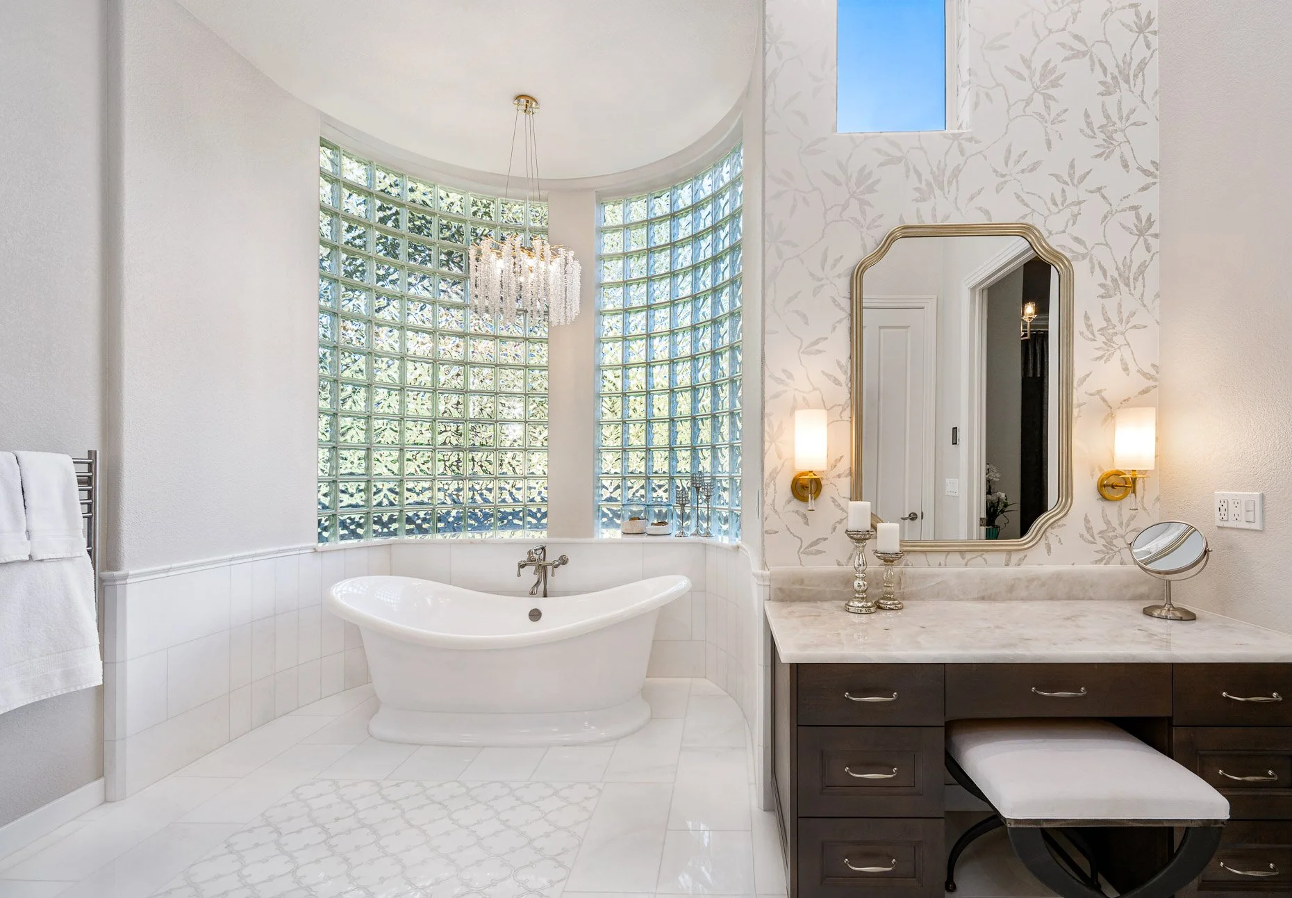 Redesigned 1970's bath with gorgeous glass block surrounding stand alone tub, dark wood vanity and gorgeous marble floors