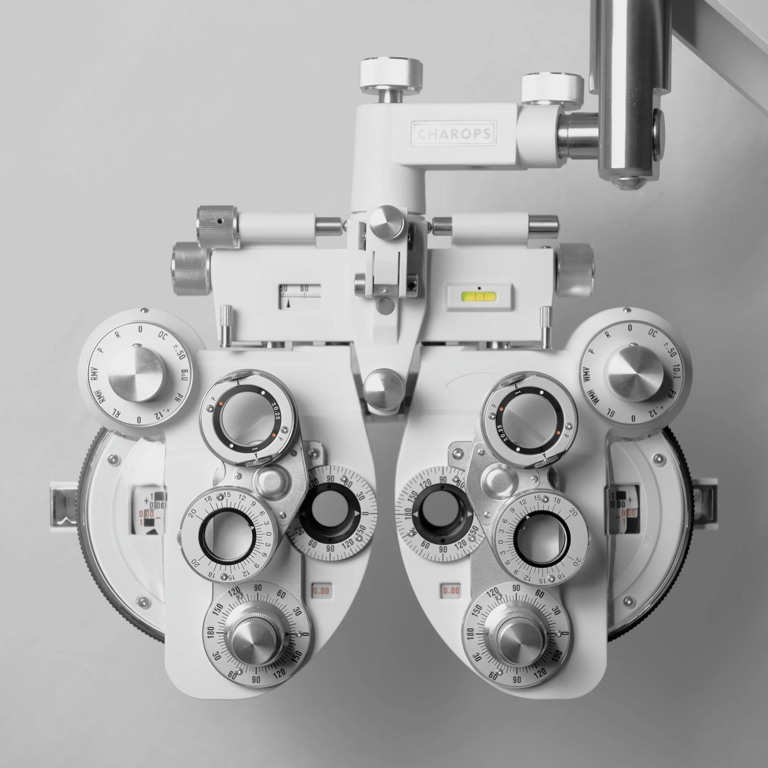 Gray ophthalmic exam equipment with multiple dials and controls.