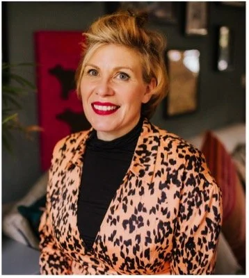 Danielle Brooks, founder of Brooksmiths executive coaching consultancy wearing a leopard print dress and black top, smiling in an indoor setting.