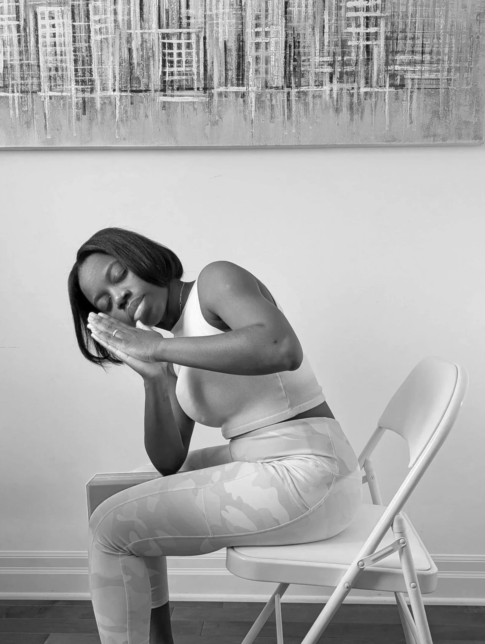 Femme assise avec ses mains jointes en position de prière ou de méditation.