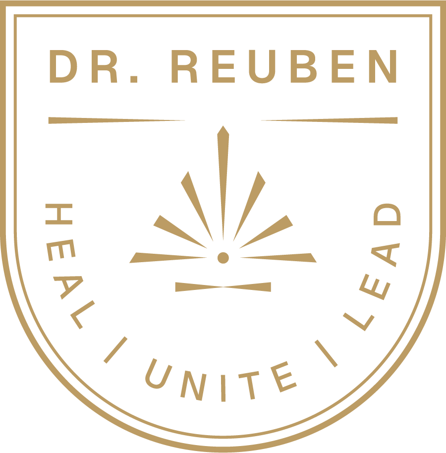 A black circular emblem with gold text that reads 'Dr. Reuben' at the top and 'Heal, I Unite, I Lead' at the bottom. In the center, there is a stylized design resembling an abstract sunburst or explosion.