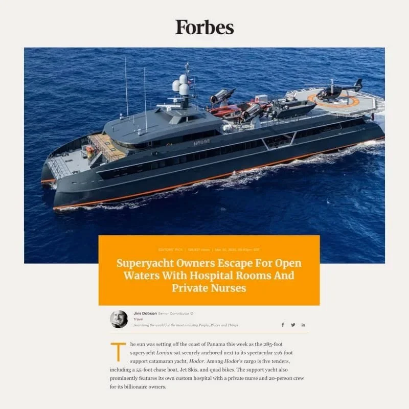 Photo of a large black superyacht with a helicopter on the helipad in the ocean.