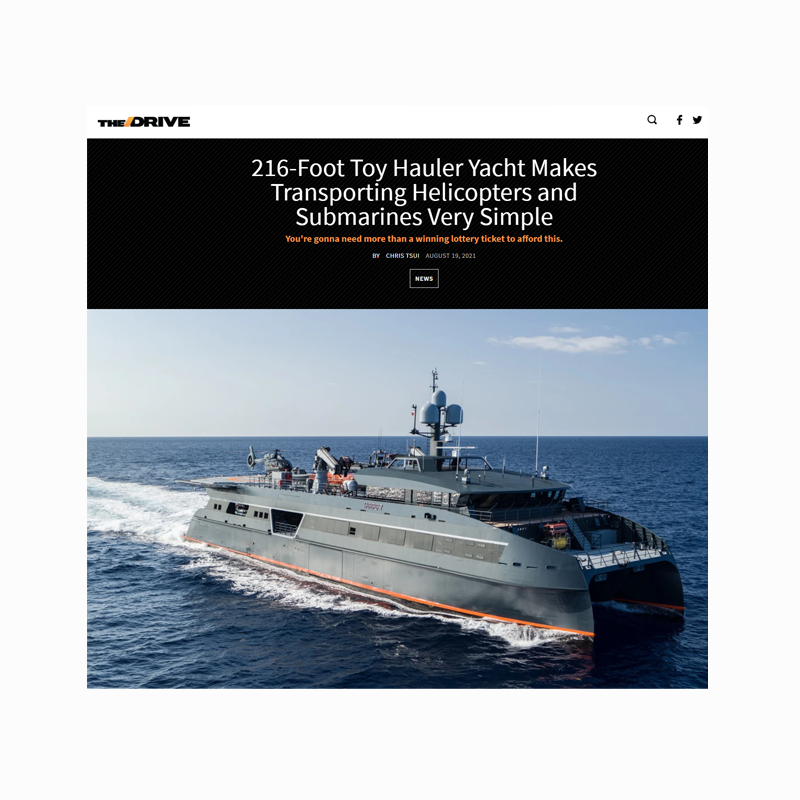 A large gray toy hauler yacht sailing on the ocean with a clear blue sky in the background.