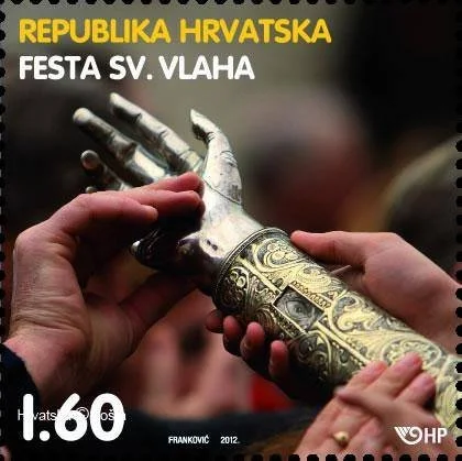 Close-up of two hands holding a ceremonial sword or dagger with ornate gold and silver decorations, set against a blurred background. Text overlay in Croatian references Croatia and a festival.