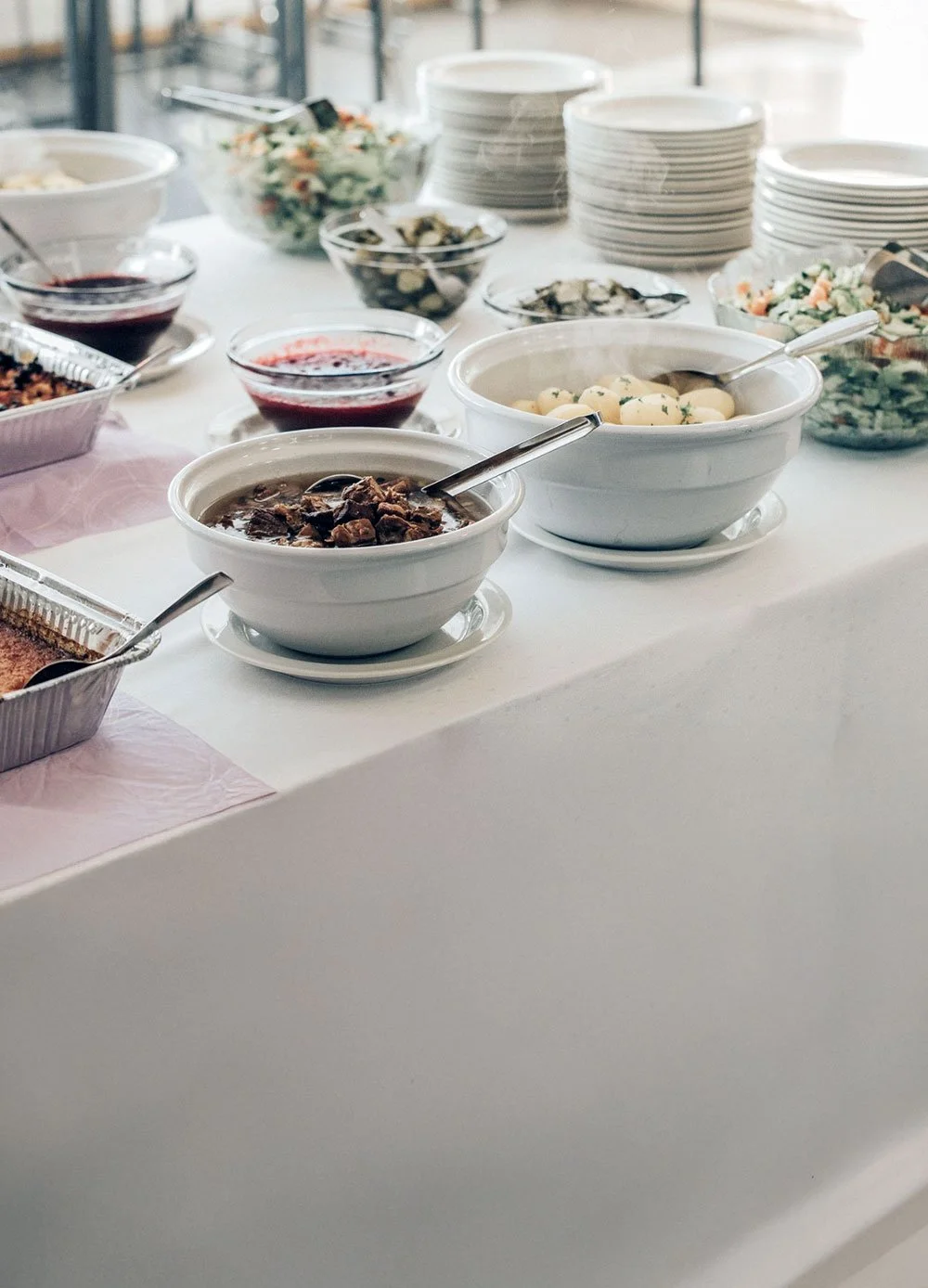 Kuva noutopöydästä, jossa on tarjolla lämpimiä ruokia ja salaatteja.