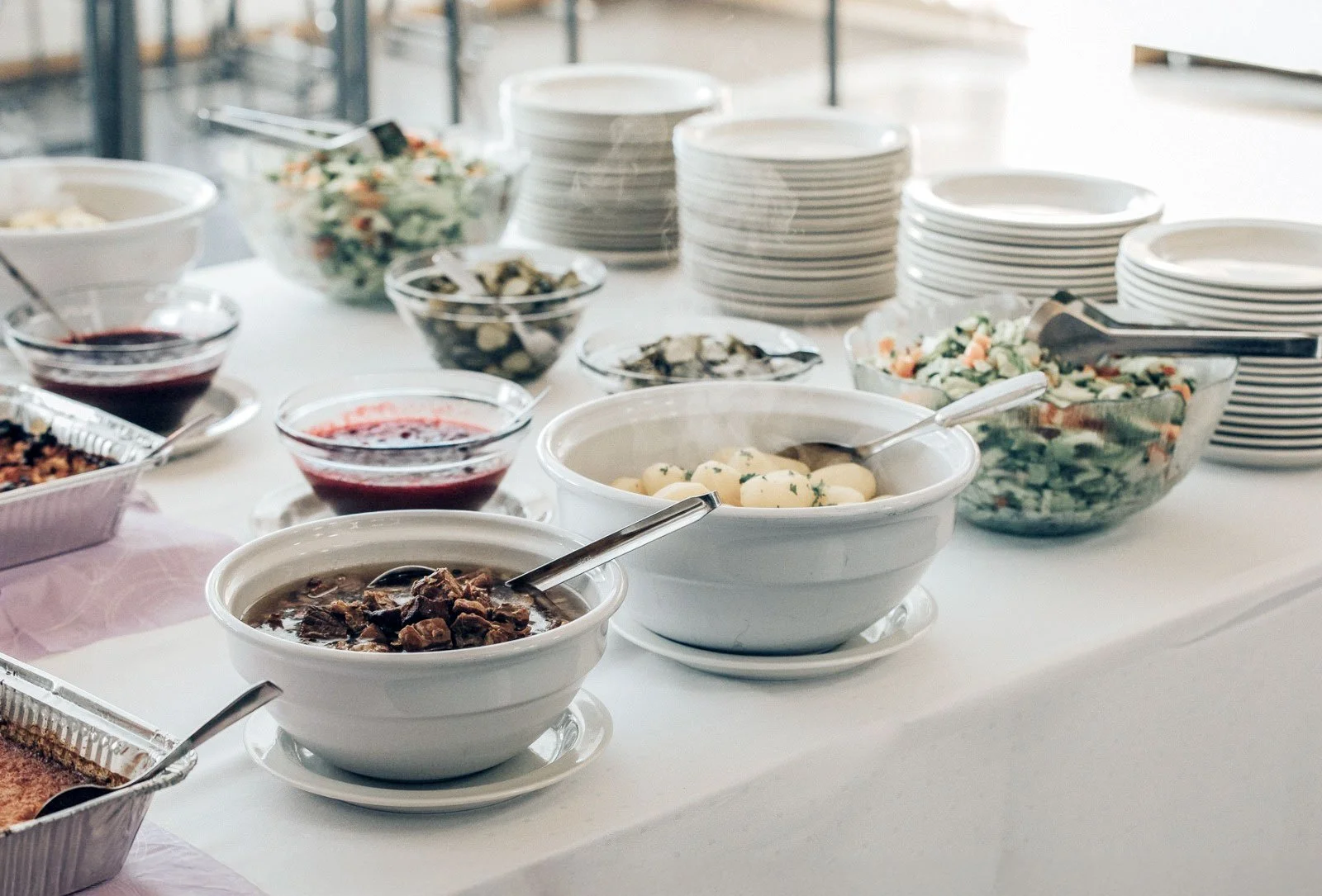 Noutopöytä, jossa on tarjolla erilaisia lämpimiä ruokia ja salaatteja.