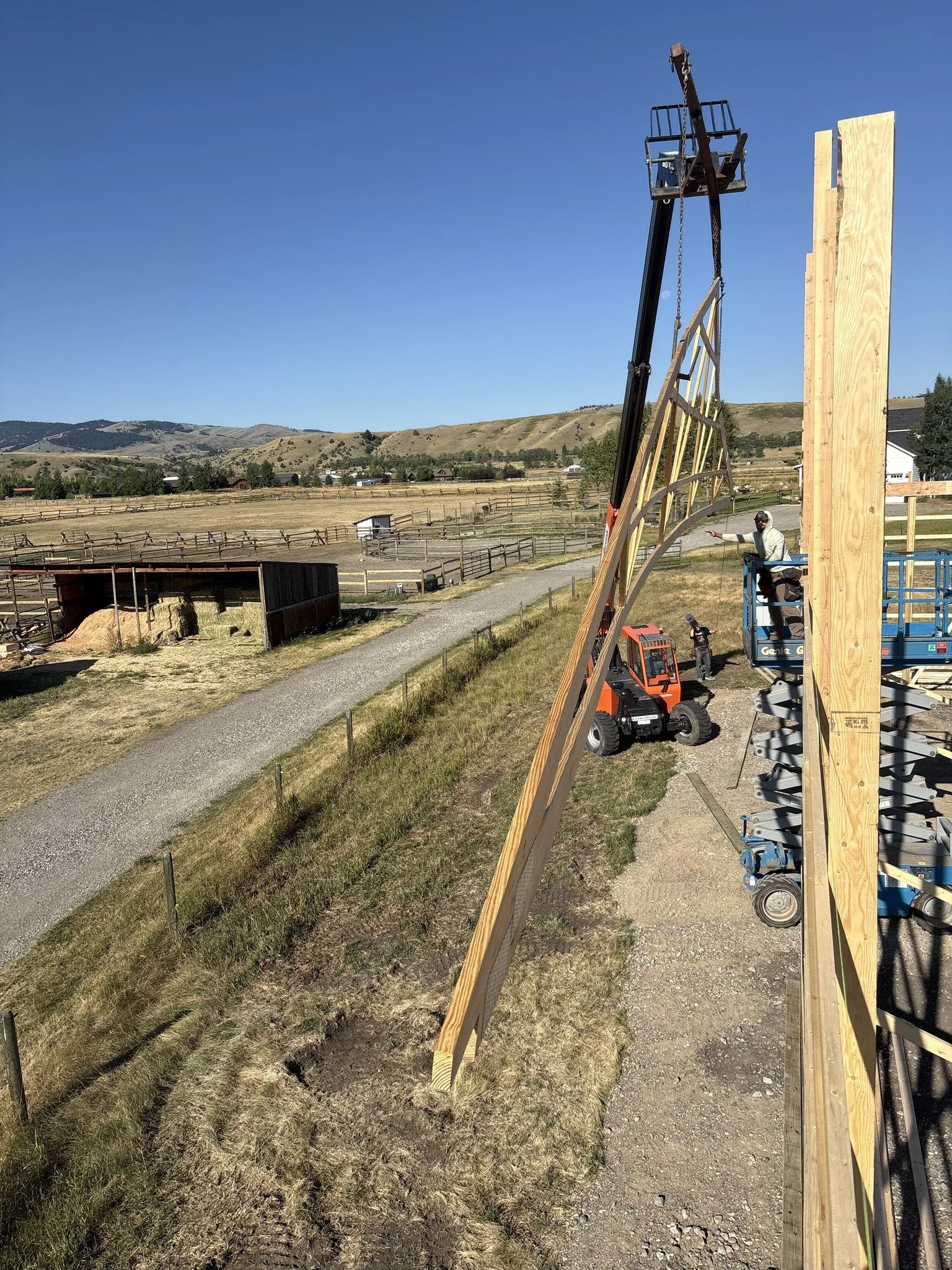 JC Borkholder Inc workers are installing a tall wooden structure with the aid of a cherry picker