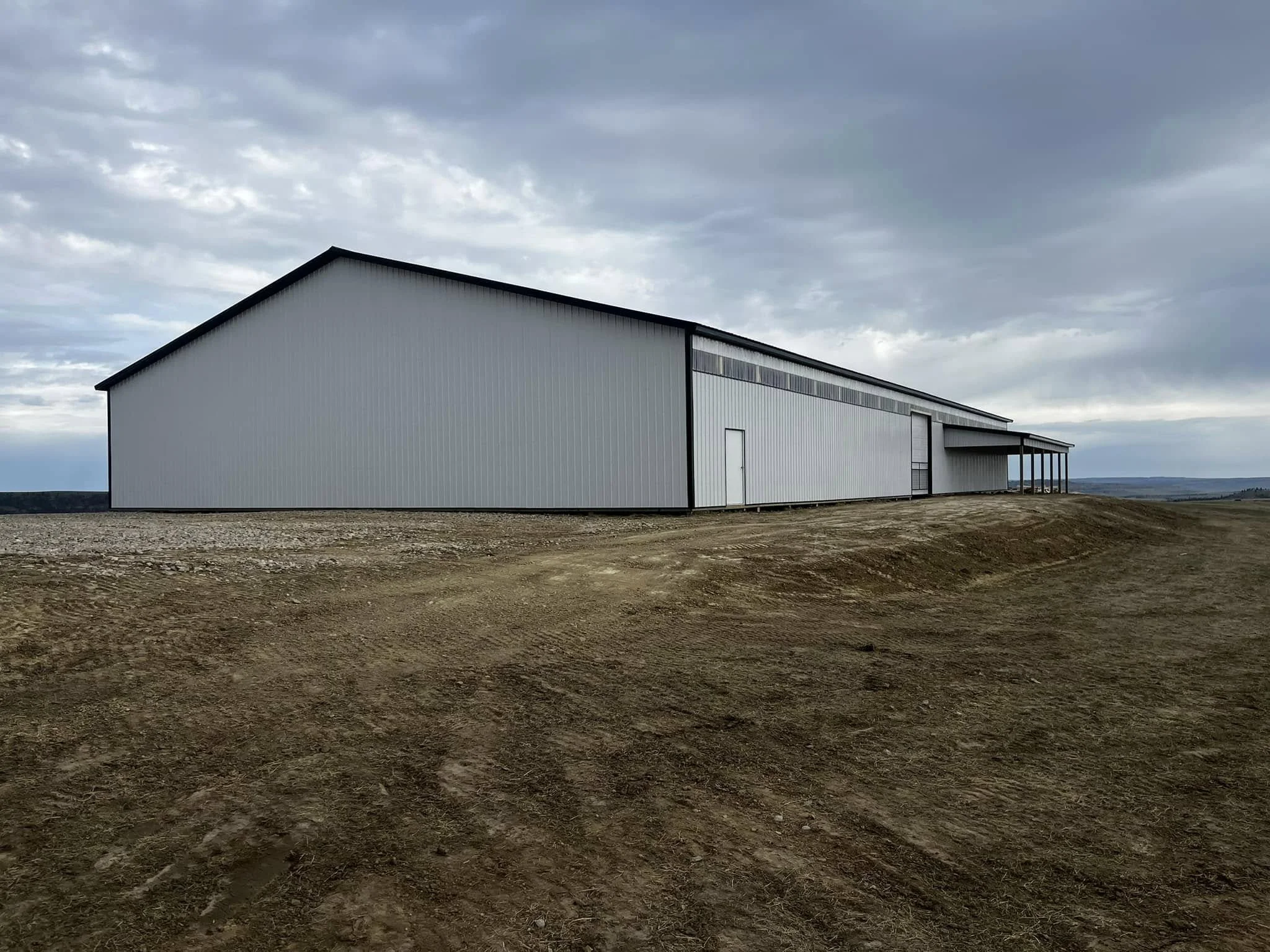 A large white metal building with a sloped roof 
