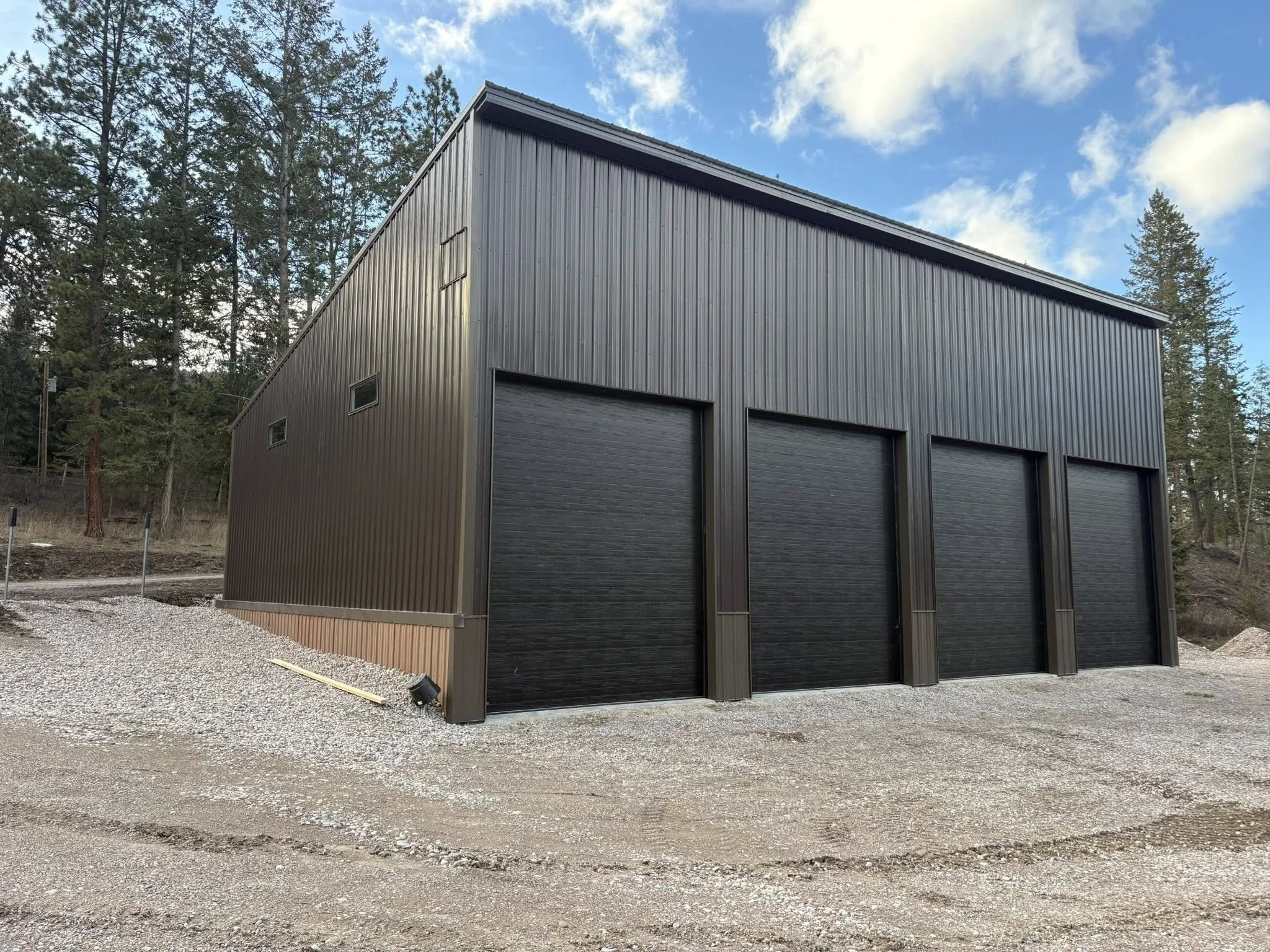 large black metal building with three garage doors, 