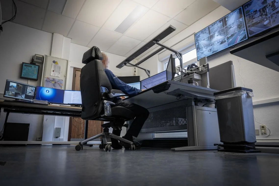 Arbeitsplatz in einer Kontroll- oder Leitzentrale mit mehreren Monitoren und Überwachungskameras.