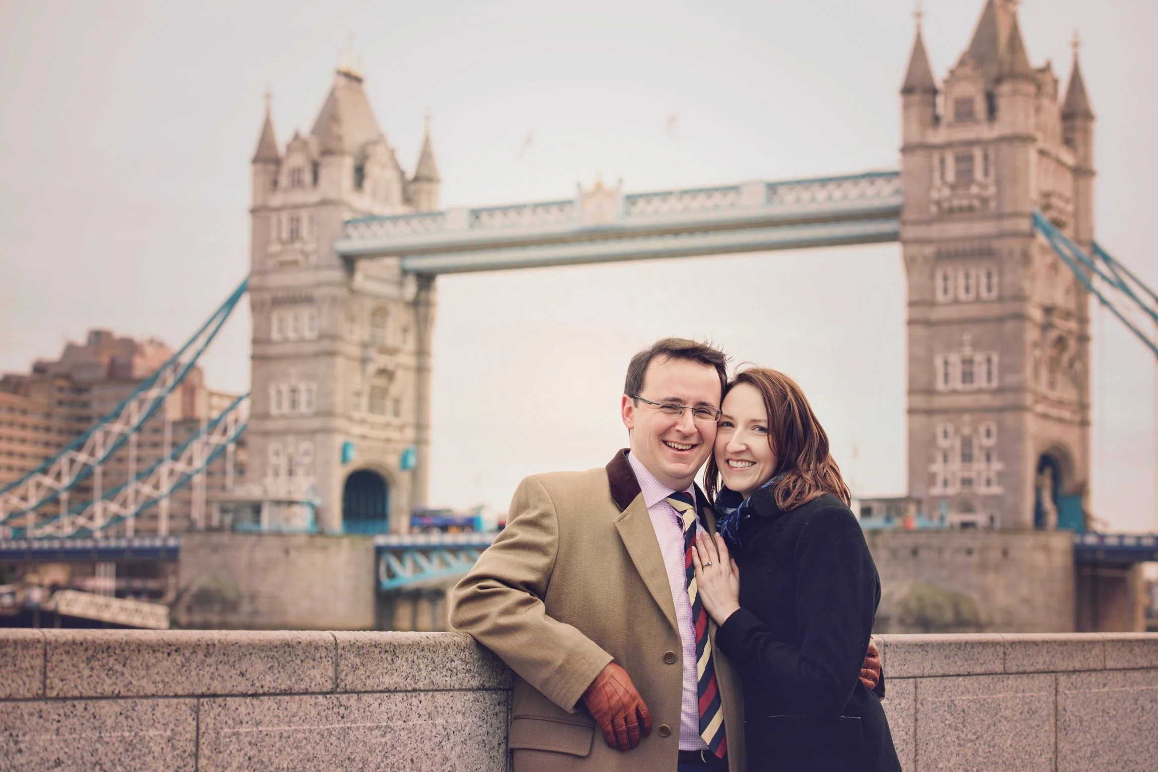 Romantic fine art photo of a smiling couple with the Tower Bridge in London in the background.