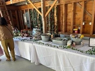 Buffet table set with food and drinks inside a rustic wooden building.
