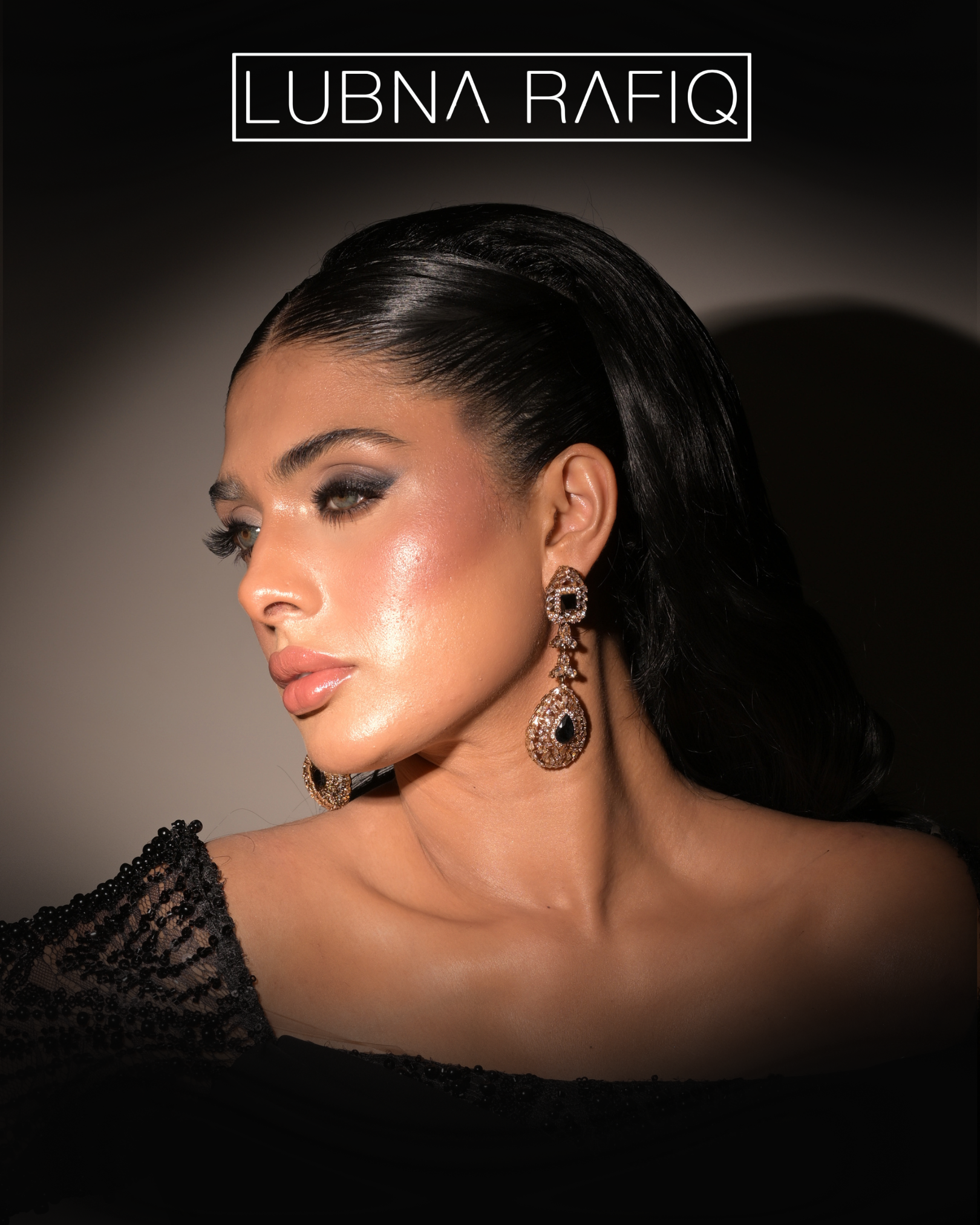 Close-up of a woman with dark hair, glamorous makeup, and large chandelier earrings, wearing a black dress with lace details.