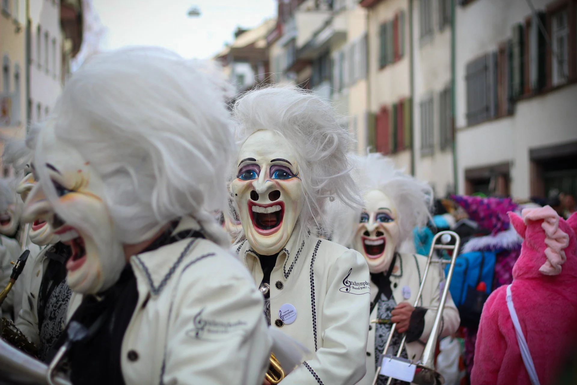 Menschen in Kostümen und Masken, die an einem Straßenfest teilnehmen.