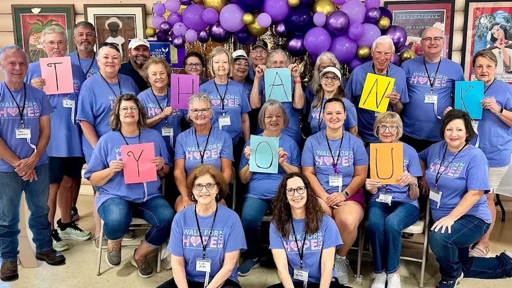 Members of Our Journey of Hope Cancer Care Ministry gathered for a group picture after the annual Walk for Hope in Kiwanis Park, holding up letters that spell out "Thank You"