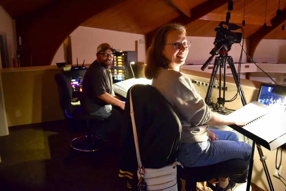 Tech and production team running lyrics, lighting, and sound during a worship gathering