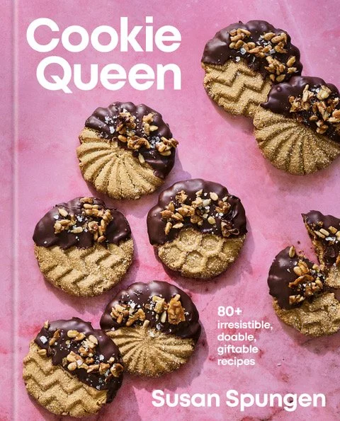 A book cover titled 'Cookie Queen' by Susan Spungen featuring several cookies with chocolate and chopped nuts on a pink background.