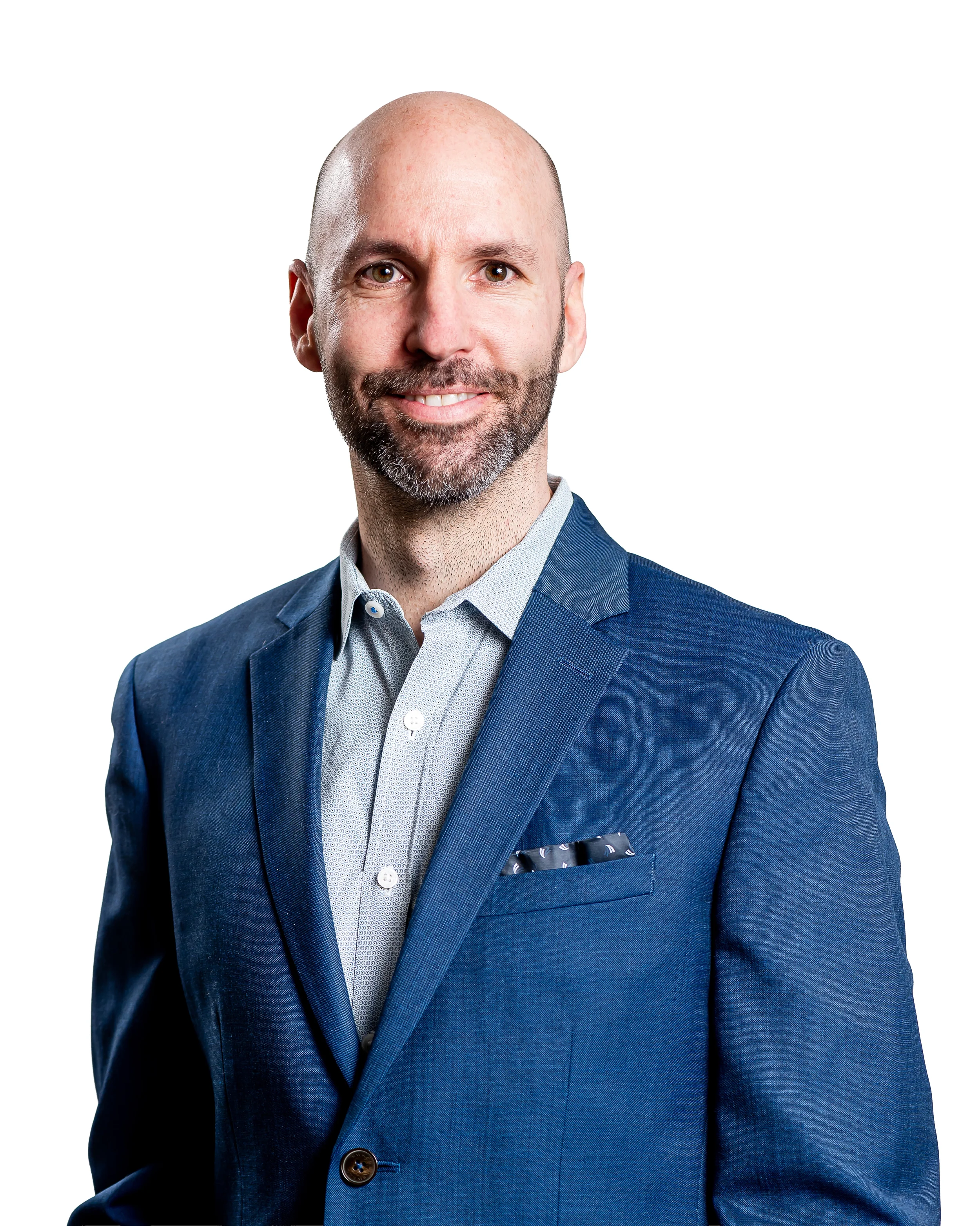 Headshot of a bald man with a beard, wearing a blue suit and a light-colored dress shirt with a patterned pocket square, smiling against a plain white background.