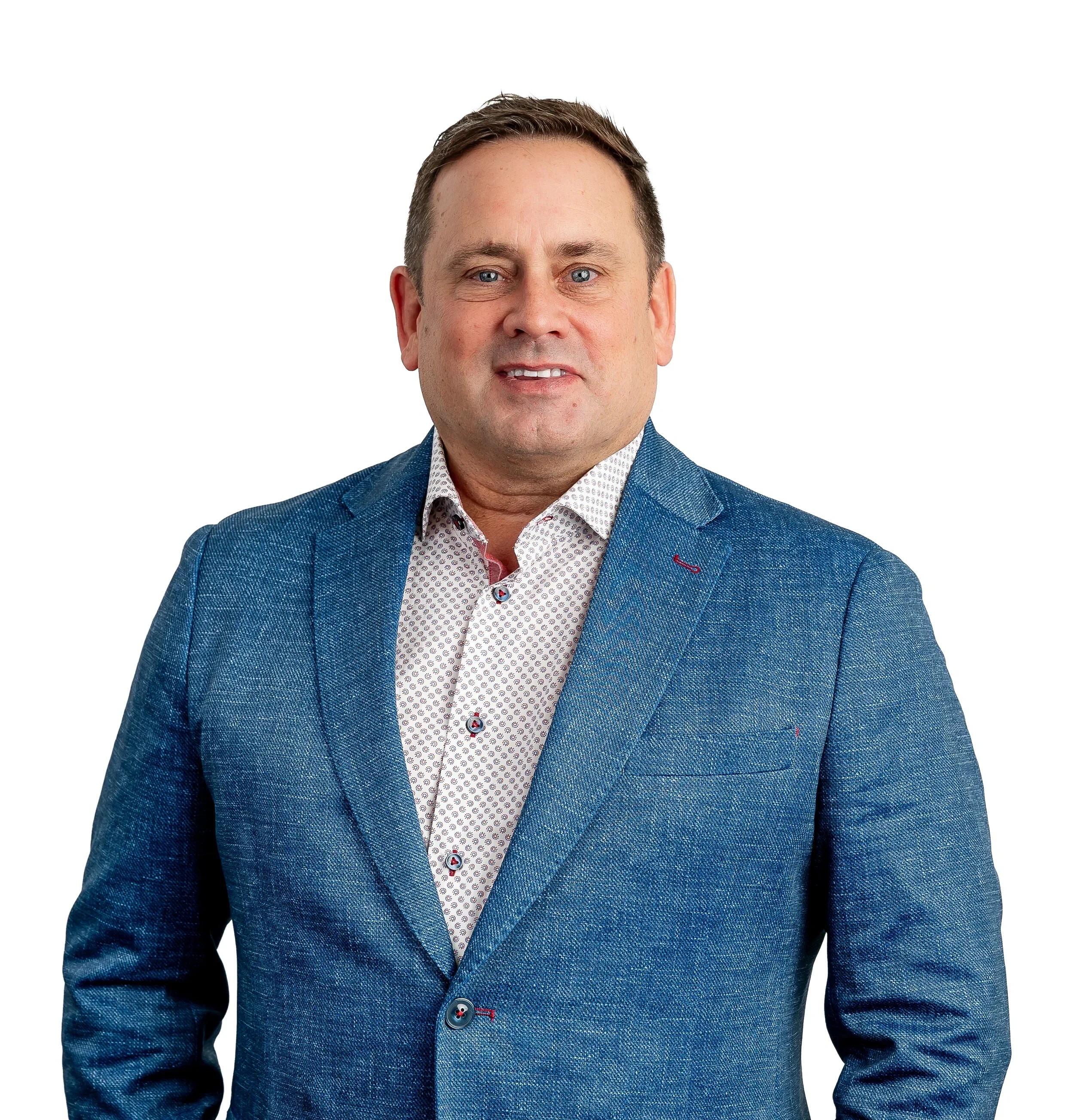 A middle-aged man in a blue blazer and white patterned shirt against a white background.