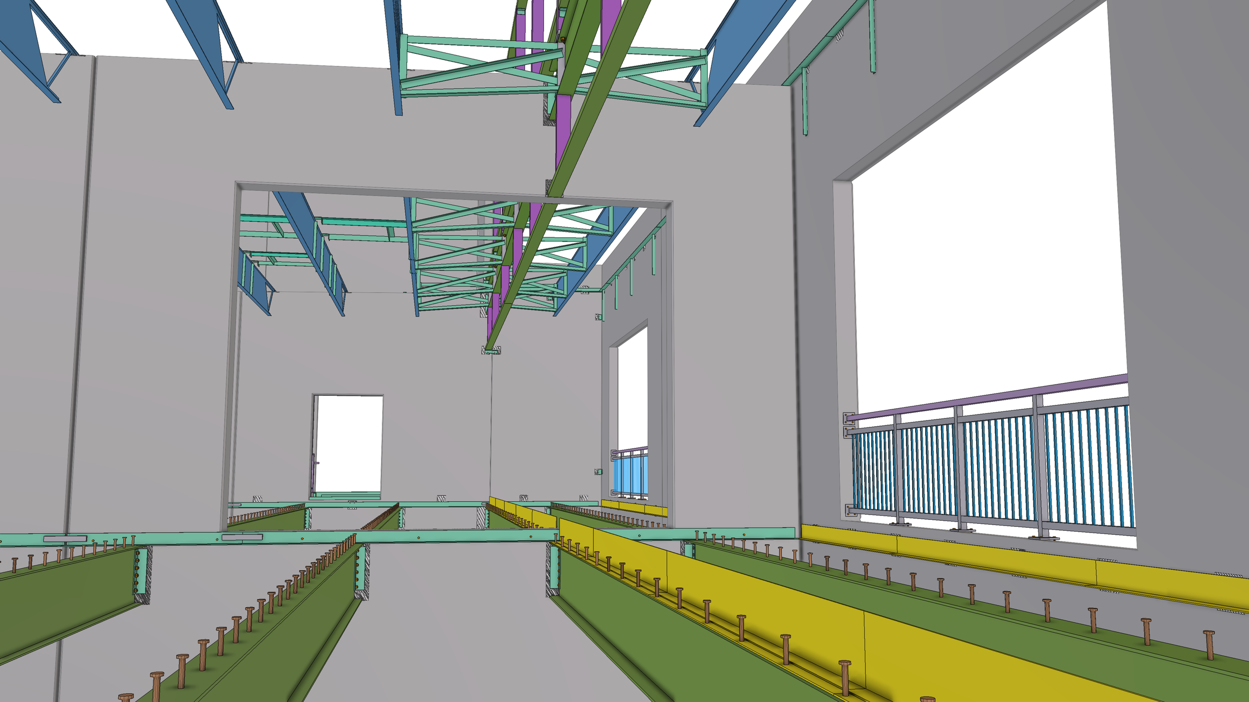 Interior view of a building under construction with steel framing, colored in blue, purple, green, and yellow, and temporary safety barriers.