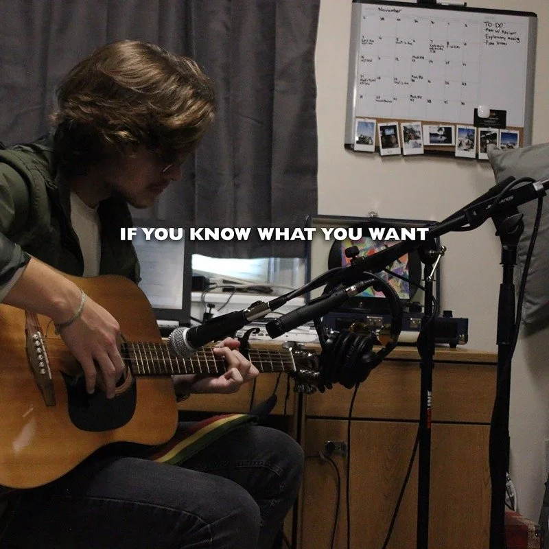 William Creamer playing an acoustic guitar in a dorm room, with a whiteboard and a few photos on the wall behind him. The text overlay says "If You Know What You Want".