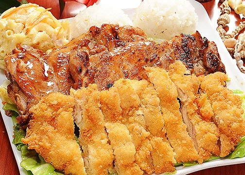 Fried chicken strips with grilled chicken, mashed potatoes, and macaroni salad on a plate.