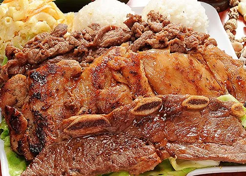 Close-up of a plate with grilled steak, roasted chicken, seasoned ground beef, mashed potatoes, and some vegetables.