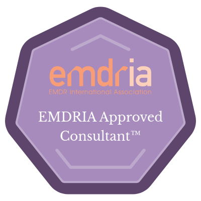 A purple octagonal badge with the text 'emdria' in orange, 'EMDR International Association' in smaller orange letters, and 'EMDRIA Approved Consultant™' in white.