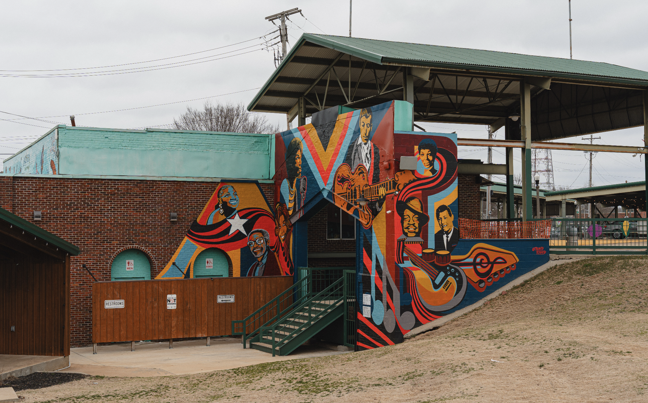 colorful mural with reds, yellows, and blues featuring iconic regional musicians, spelling out the word "AMP"