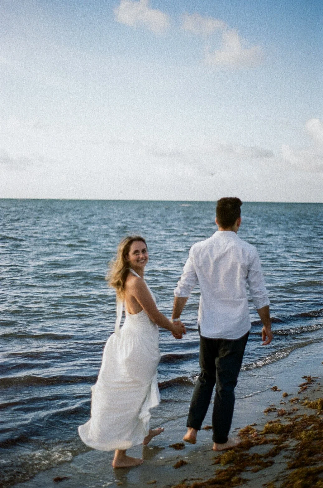 Couple walking on South Florida beach during sunrise