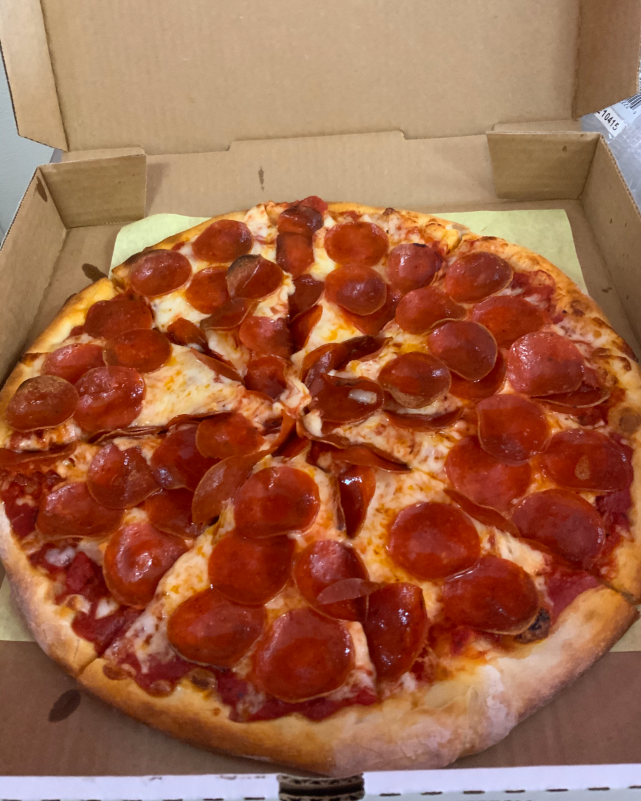 Pepperoni pizza in an open cardboard box.