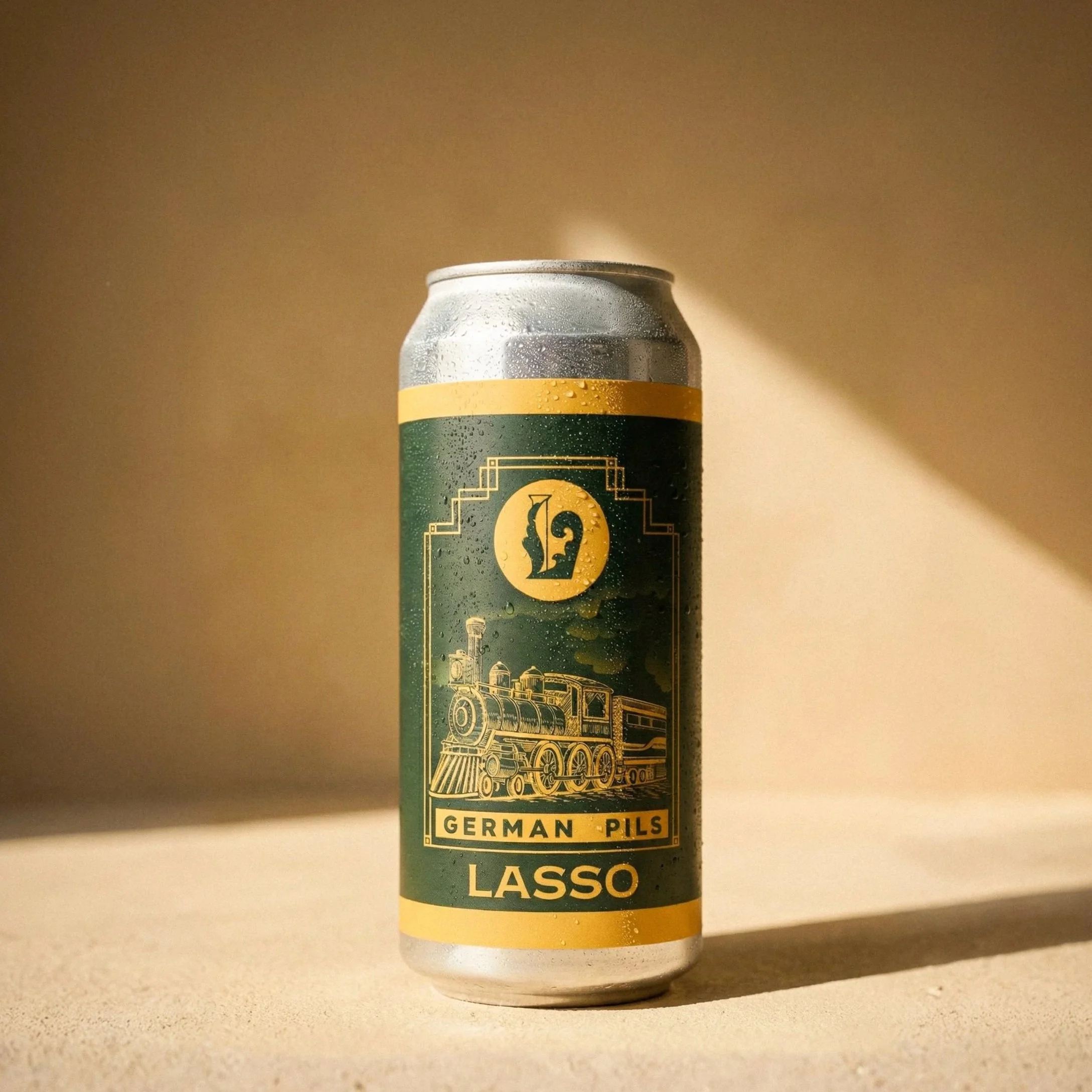 A can of Lasso German Pils beer with a vintage train illustration on the label, condensation droplets visible, set against a beige background with sunlight and shadow.