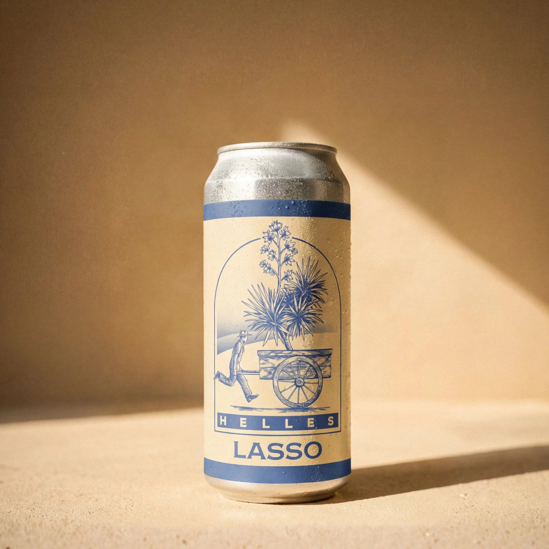 A can of Helles Lasso beer with a blue and beige label featuring a drawing of a man pushing a wheelbarrow with large plants, set against a beige background with a diagonal shadow.