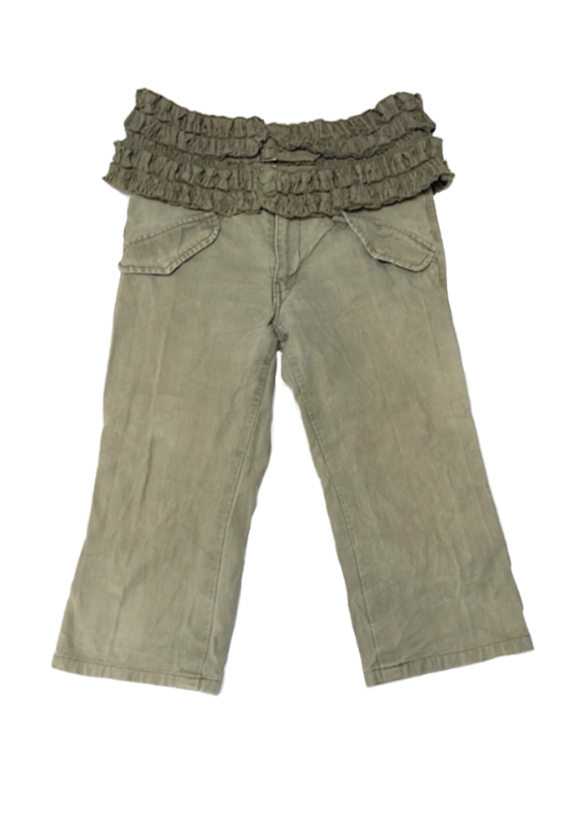 A pair of beige pants with a ruffled waistband, possibly made of a soft fabric, laid flat on a surface.