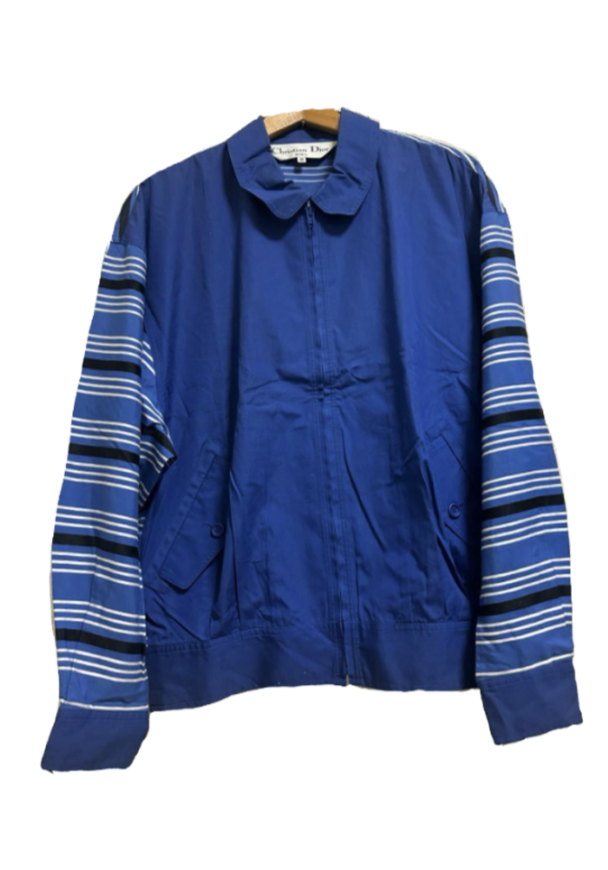 A blue jacket with striped sleeves hanging on a wooden hanger.
