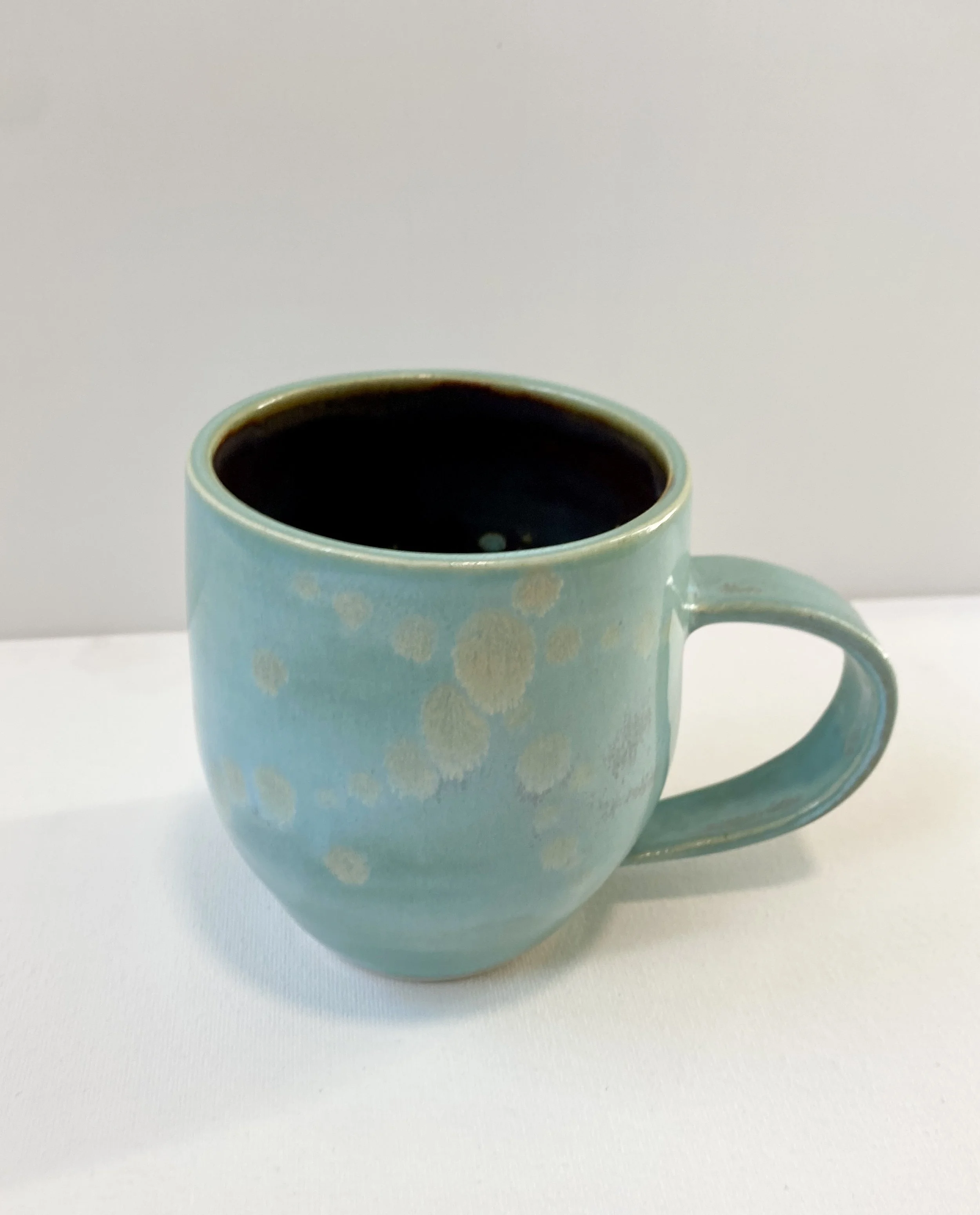 light blue mug with light dots in glaze with brown metallic interior