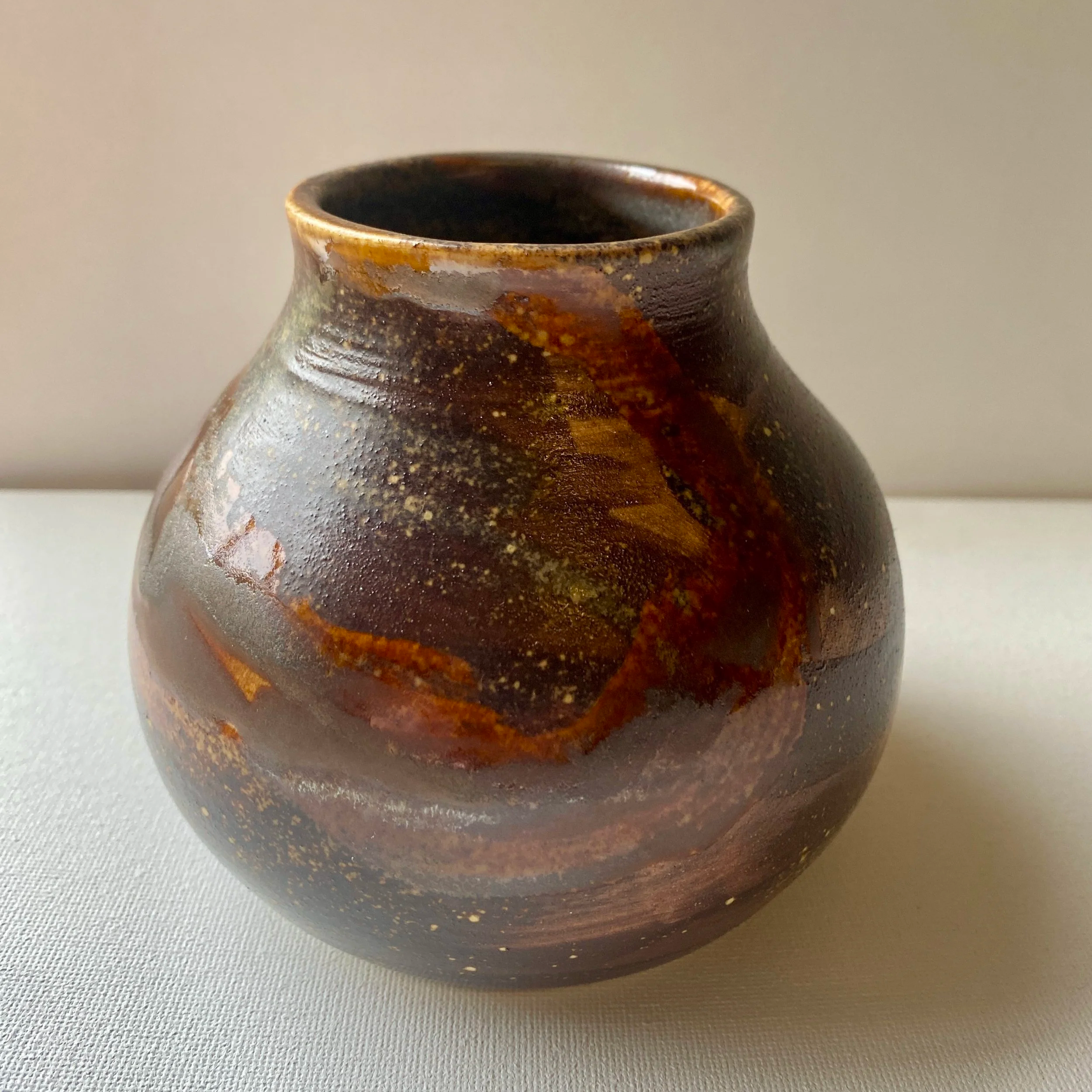 brown vase with brown tone designs in the glaze