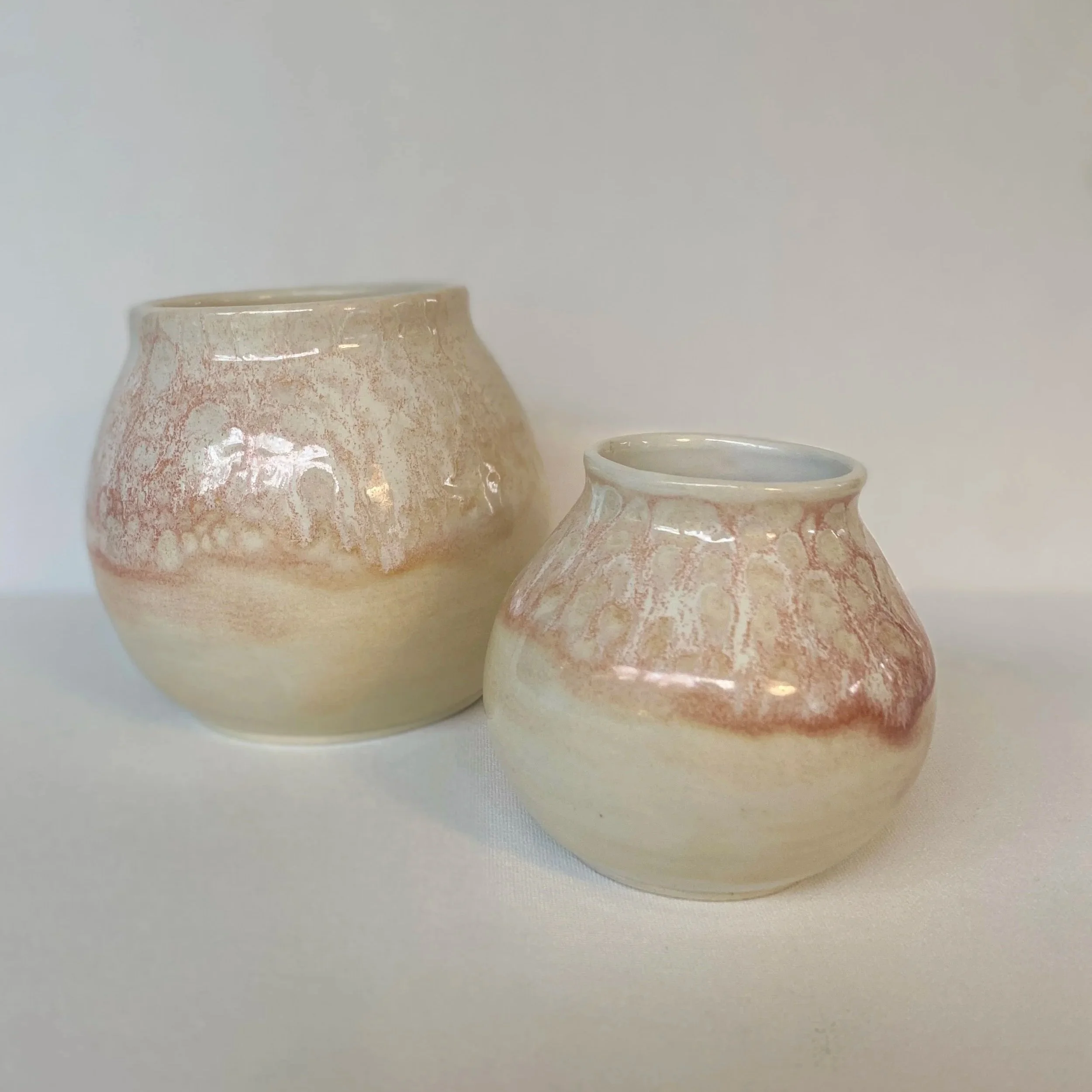 two small coral vases with dripping glaze