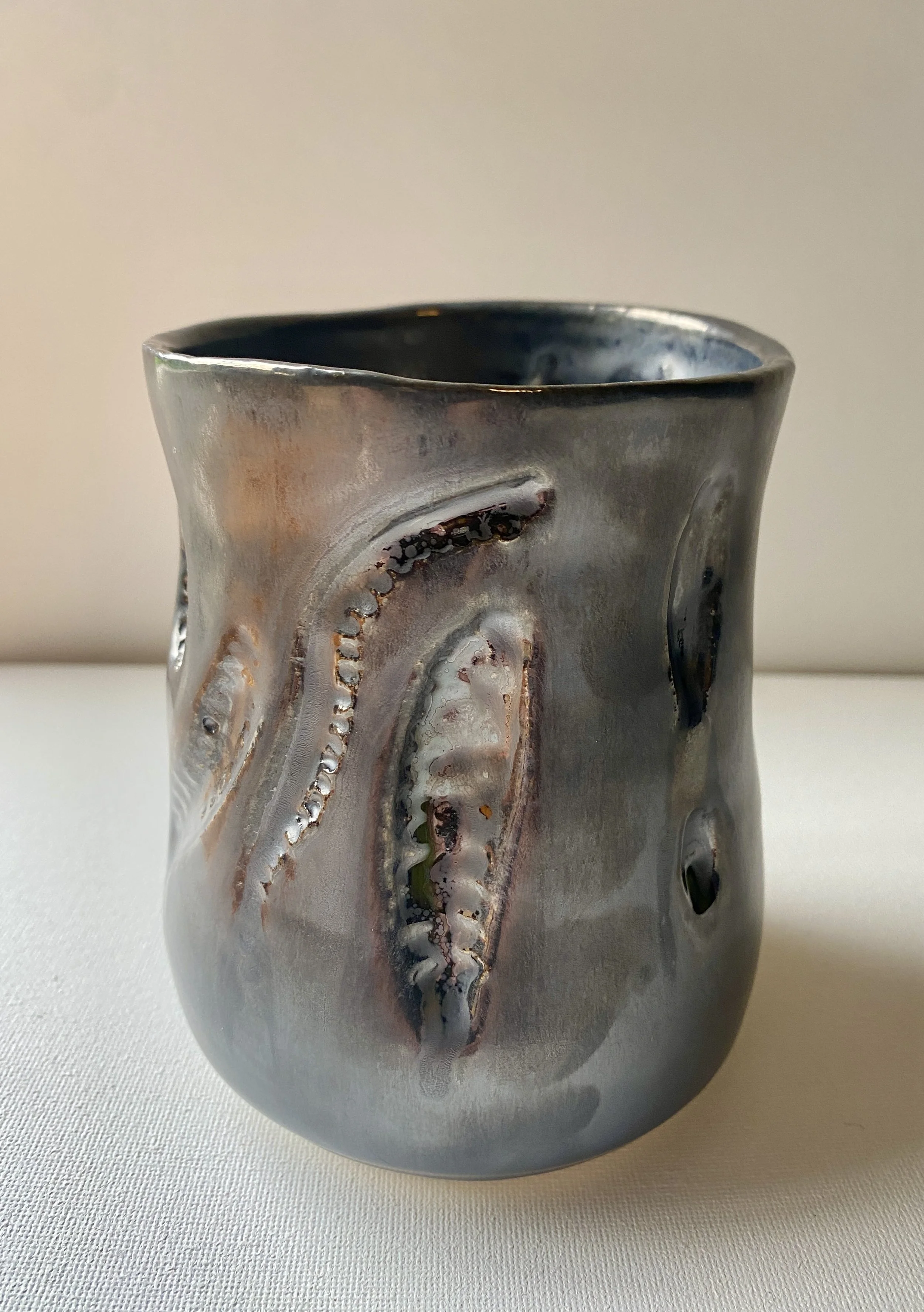 metallic vase with carved abstract leaf shapes
