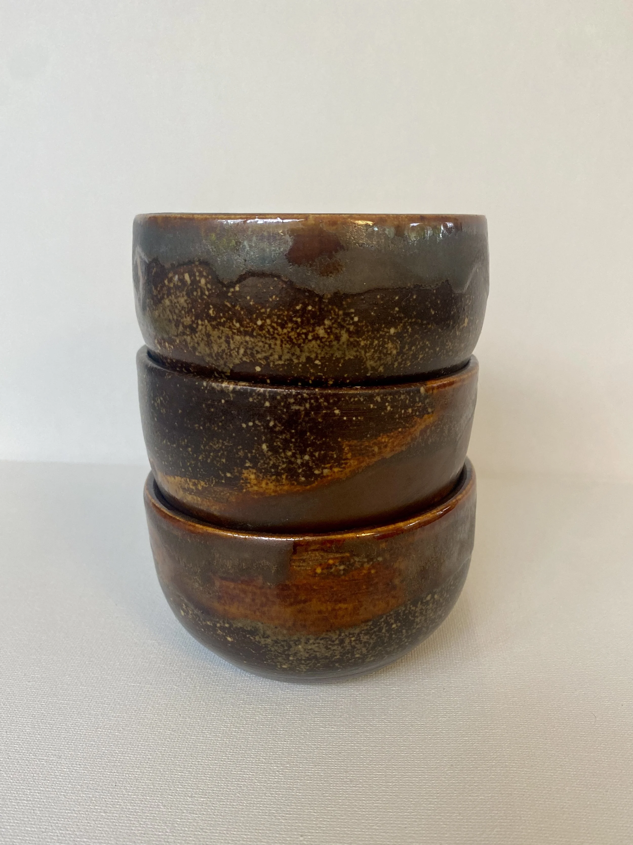 three small brown metallic snack bowls stacked