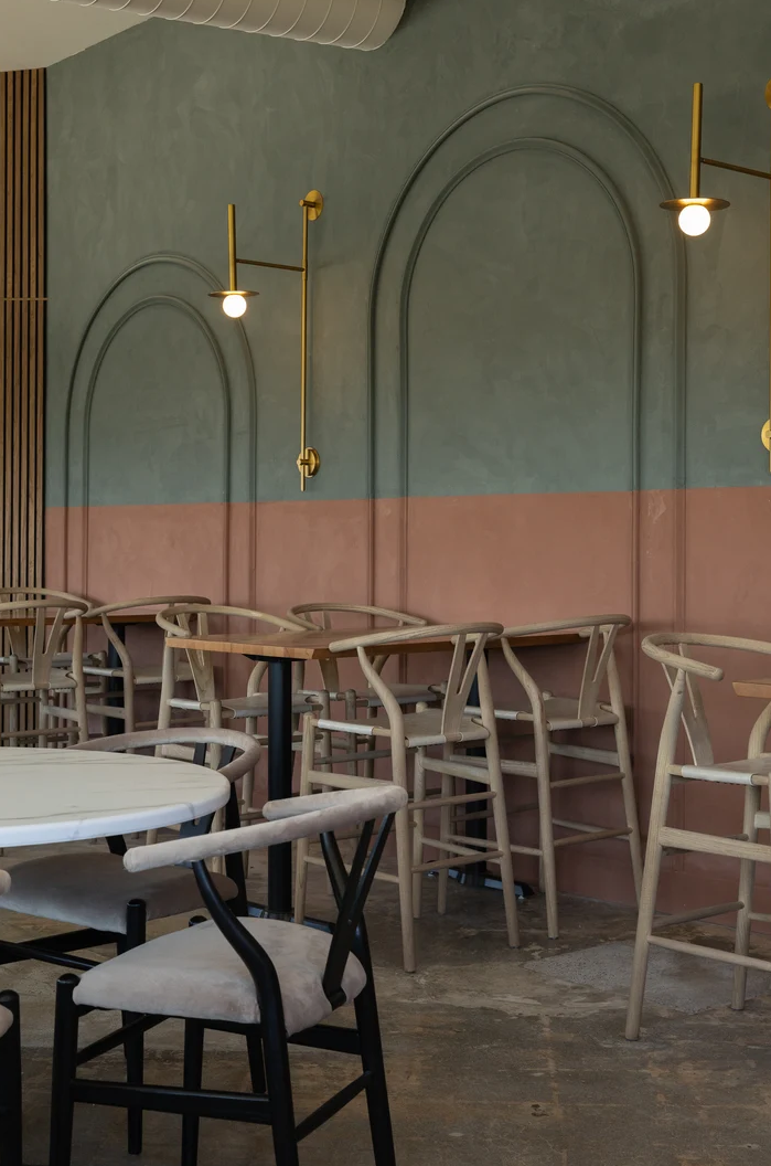 Cafe interior with pastel blue and pink limewash walls.