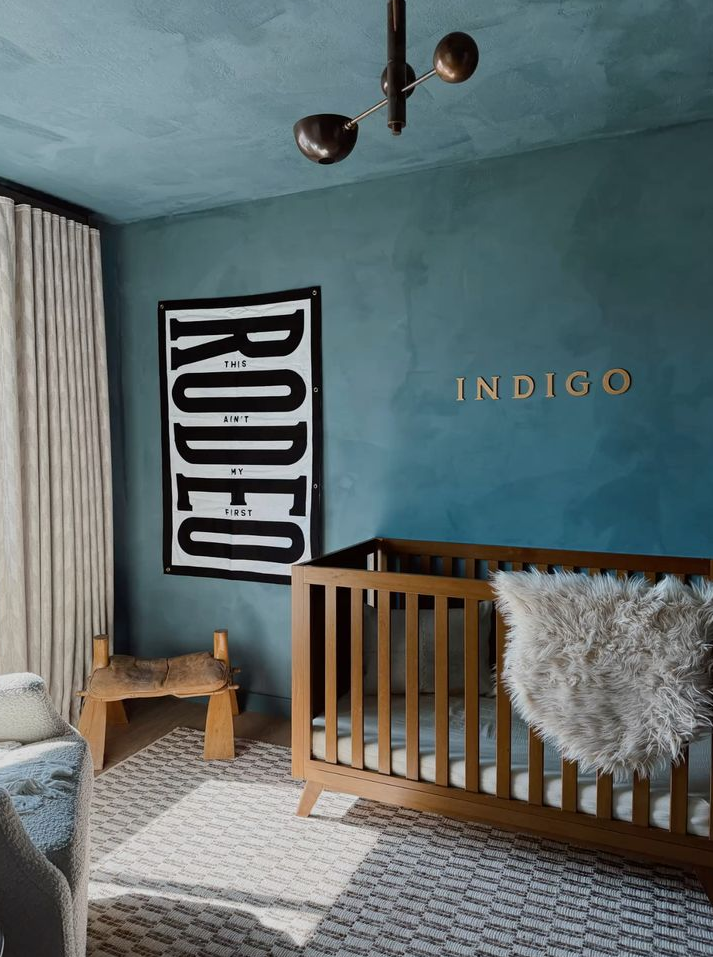 A nursery room painted in blue natural limewash.