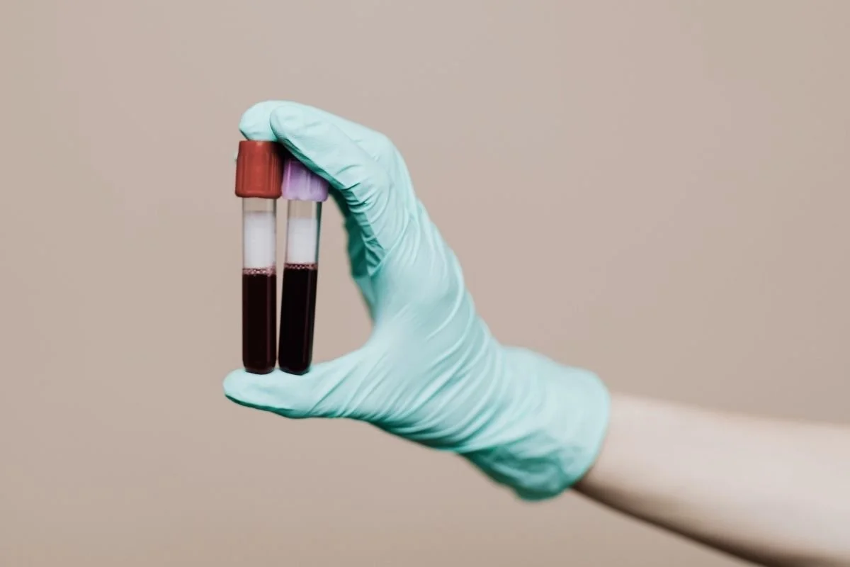 A provider holding vials of blood which will be sent for lab testing.