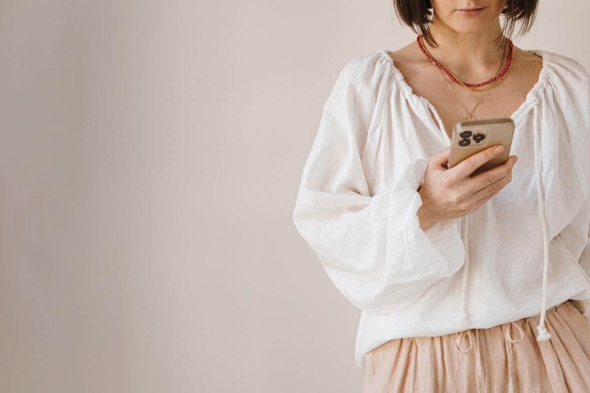 Middle aged woman looking at her phone.  She is researching hormone optimization treatments. 