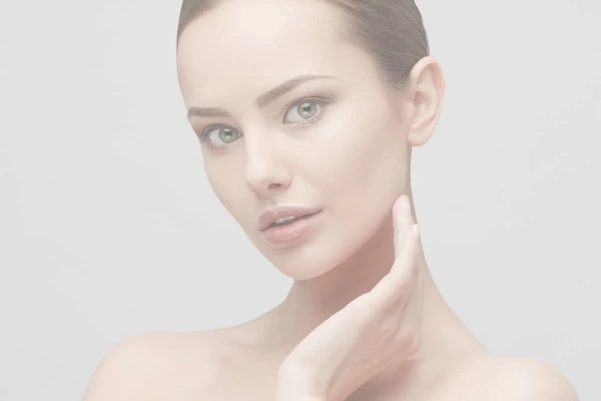 Close-up of a young woman with clear skin touching her neck