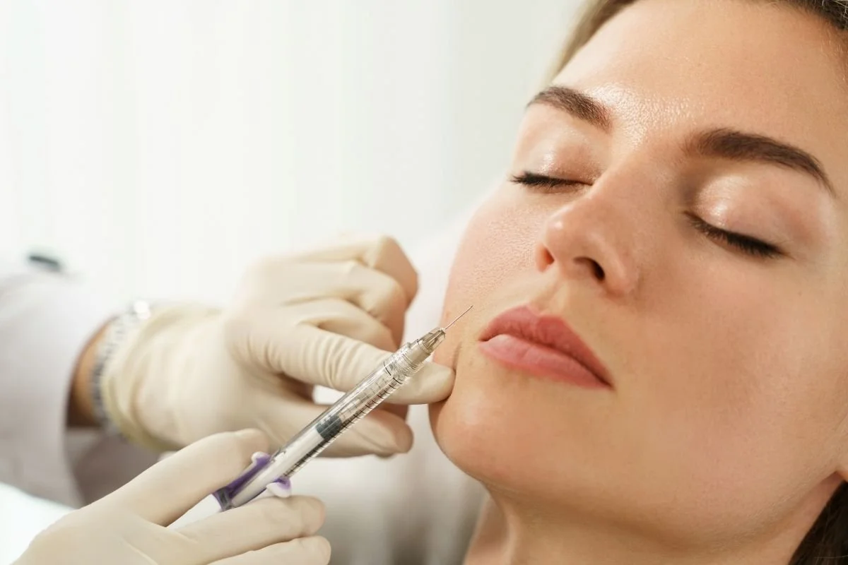 Woman receiving neuromodulators to reduce fine lines.