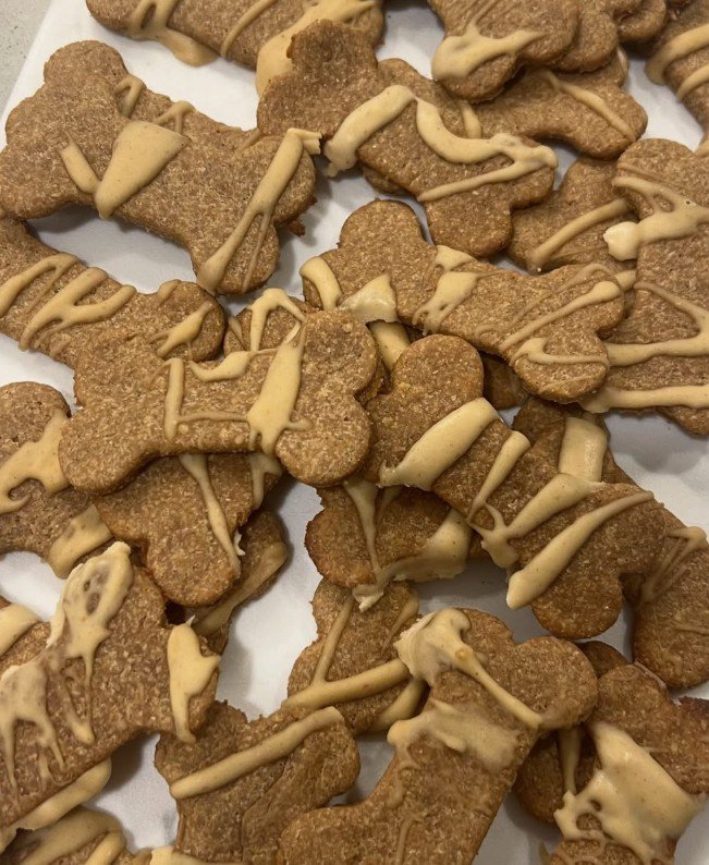 Dog-shaped cookies with light-colored icing drizzle.