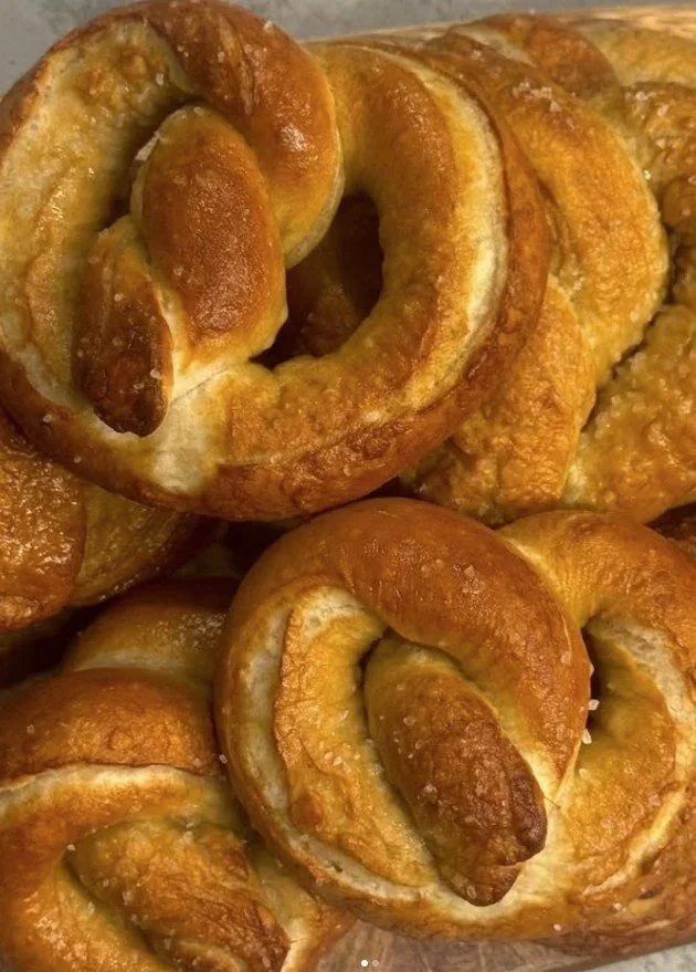 Close-up of multiple golden-brown cinnamon rolls with a shiny glaze.